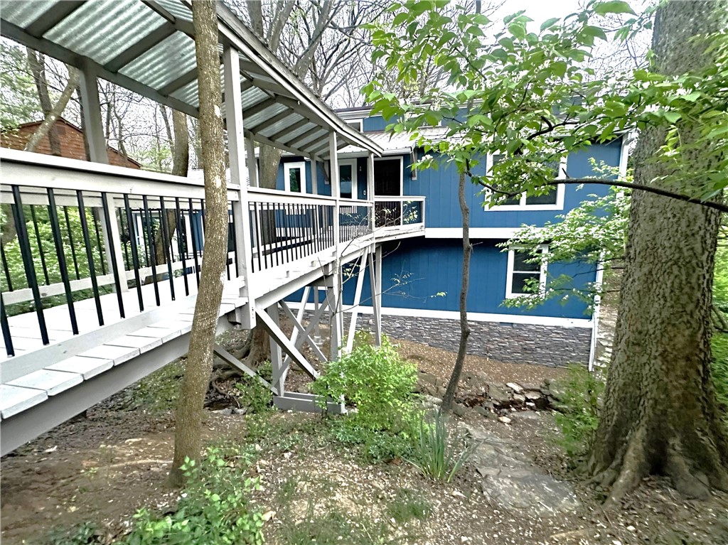 This stunning home is truly one-of-a-kind...surrounded by nature and conveniently located in the heart of the city. Only 0.9 miles to the U of A, 1 mile to Dickson Street, 1.5 miles to downtown, 2.5 miles to I-49, 1 block to Razorback Greenway trail system, and walking distance to the VA Medical Center, UAMS, Gregory Park, Wilson Park, stores, breweries, and restaurants. Relax and unwind to the soothing sights and sounds of the waterfall and creek. And enjoy nature views from every window and door in the 1,790 SF home, 100 SF workshop, and 473 SF heated/cooled detached bonus room that is perfect for an office, game room, or home gym. Other features include vaulted ceilings, stack stone gas-log fireplace, spacious rooms, walk-in closets, and multiple decks. Completely remodeled in 2023, new GE appliances, water heater in 2023, HVAC in 2020 (home) and 2024 (bonus room), metal roof in 2014, and crawl space encapsulation in 2023. All appliances & Ring security system convey. Furnishings are negotiable. No HOA/POA.