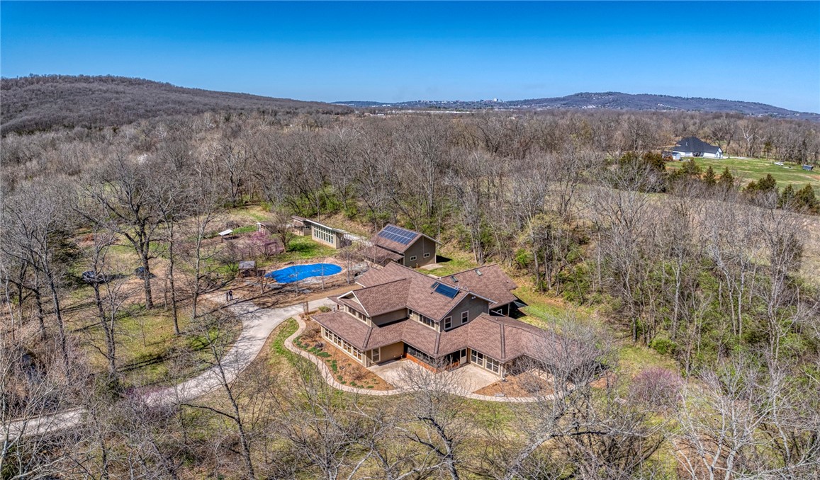Beautiful estate on 47 acres (MOL). Just 10 minutes from downtown or groceries and 15 minutes to the University of Arkansas and I-49. Stitt Energy Star passive solar home with Ice House roof design. Large 30,000-gallon inground saltwater pool with grotto waterfall. Property includes large barn, heated and cooled shop with 2 large garage doors, a garden shed, and chicken coop. Solar panels cover all electrical on the entire property. Creek with bridge and over 800 feet of frontage on the West Fork of the White River. Property has many riding and 4 x 4 trails. Please see attachment for a list of many more amenities.