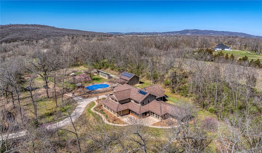 Beautiful estate on 47 acres (MOL). Just 10 minutes from downtown or groceries and 15 minutes to the University of Arkansas and I-49. Stitt Energy Star passive solar home with Ice House roof design. Large 30,000-gallon inground saltwater pool with grotto waterfall.  Property includes large barn, heated and cooled shop with 2 large garage doors, a garden shed, and chicken coop. Solar panels cover all electrical on the entire property.  Creek with bridge and over 800 feet of frontage on the West Fork of the White River. Property has many riding and 4 x 4 trails.  Please see attachment for a list of many more amenities.