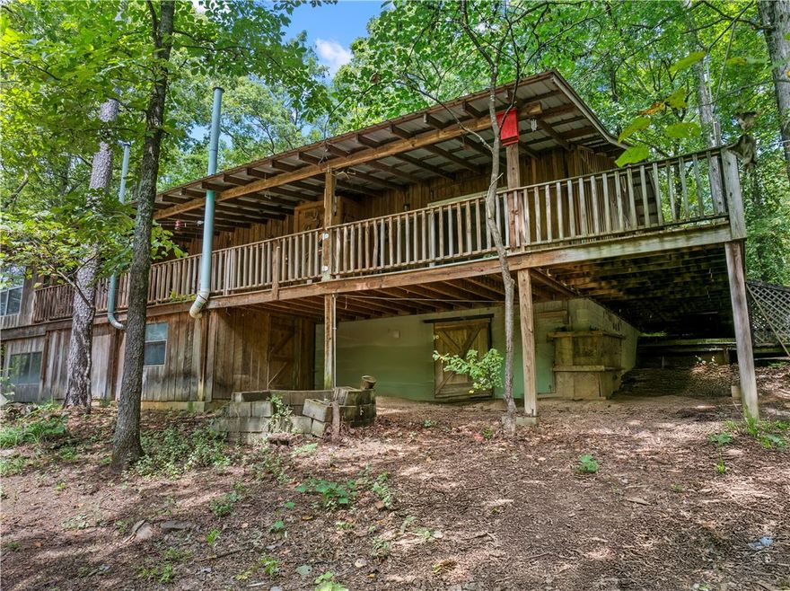 Tucked away at the end of NC 8700, this private retreat is perfect for anyone who craves peace & nature. The custom 2-bed, 2-bath cabin sits on 9± wooded acres with a fully stocked pond—ideal for reeling in catfish or soaking in the view. The south line boasts approx. 800 feet of creek frontage, adding even more beauty & recreation.

Inside, spacious bedrooms pair with a large kitchen featuring hickory cabinets, an oversized island with propane cooktop, & a walk-in pantry. The cabin is fully insulated, equipped with propane backup heat, & even includes a propane light in the kitchen for outages—true off-grid peace of mind.

Step onto the covered back porch, with a screened-in section for year-round enjoyment, or head outdoors where a metal barn offers extra storage. With abundant wildlife & endless privacy, it’s a hunter’s paradise.

Whether for weekends or a full-time lifestyle of seclusion, fishing, & the sound of the creek, this cabin delivers it all.