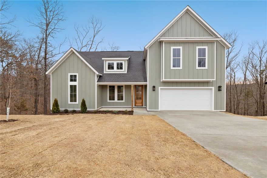 This gorgeous new construction home has a perfect layout both for entertaining and a seamless flow of everyday living. This stunning open floor plan features a primary ensuite on main & and 2 additional bedrooms, office plus a flex room and full bath upstairs. Upgraded 3cm quartz counters, beautiful hardwoods throughout main & tile work add luxury and charm to this home! You will appreciate the custom home finishes that set this spec home apart from others in the area. Come home & kick your shoes off in the mud room, drop your socks into the laundry room and grab a snack from the huge pantry on your way in. The large covered deck and privacy in the backyard offer peace and tranquility among the hardwood trees. The kitchen features soft-close cabinets and drawers that complement the serenity of the space. *Photos are of a previous build on steeper lot.  This lot is flat. Interior finishes may vary slightly from photos.