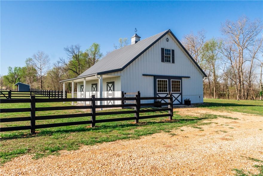 Come experience the peacefulness of this 8.82-acre property near scenic Spavinaw Creek, complete with equestrian barn, garden, greenhouse, loafing shed and more. Enjoy rural charm with modern convenience, with buried power lines and city water at the property line. The pasture is bordered on three sides by a black-stained four-rail fence with cedar posts and oak rails. The 36’x36’ three-stall barn features a spacious loft, Dutch doors, breezeway with sliding doors, tack and storage rooms, concrete floors, electricity, and a 30 AMP RV plug. A four-rail corral with dual gates and a 12’x24’ loafing shed with overhang and reclaimed kick boards add to the horse-ready setup. Gardeners will love the 7,616 sq. ft. fenced garden with in-ground beds, raised beds, and a 175 sq. ft. greenhouse/potting shed with paver-stone floor and shelving. Two blackberry trellises, an orchard with peach, pear, and apple trees, plus compost bins complete the amenities. Wildlife abounds, with deer, small game, birds, and winter bald eagles.