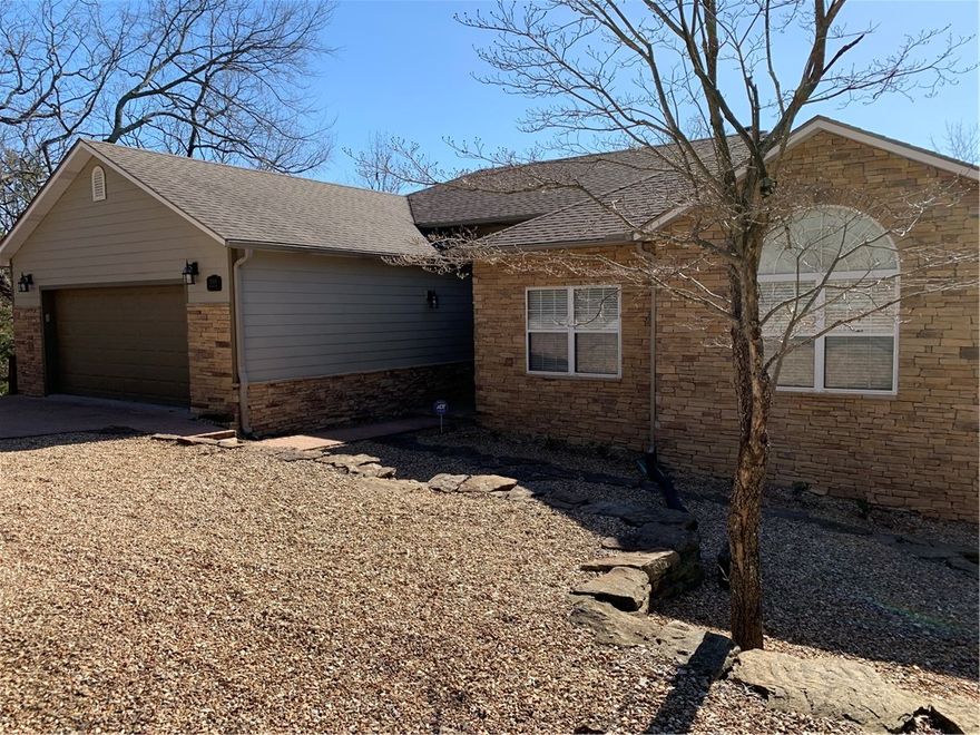 Lost Bridge Village--Beautiful lake front home, spacious, immaculate, and only steps away down a meandering path to a private 2 slip boat dock. Slips are 10' x 26' with lifts, 12' wide swim deck, and is located in quiet wake free Sailboat Cove.  Floor plan includes 5 bedrooms, 3 full baths, eat-in kitchen, dining room, 2 car garage, multiple living areas, walkout basement and plenty of room to entertain on upper and lower decks. Fresh paint, new flooring, and new kitchen appliances are recent updates.  All furniture and furnishings to convey with sale.  Lost Bridge amenities include use of a seasonal community swimming pool, a recreational area with playground, picnic area and beach, and airstrip. The house is 30-35 minutes away from Eureka Springs, Rogers, or Bentonville.  Paved road all the way, and the 2 lots across the street are included with sale.