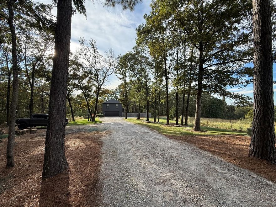 Wanting the perfect building site with living quarters already available.  Modern living quarters above an oversized 2 car garage makes this a perfect start for your Dream Home.  Fenced yard for pets, spring fed creek in rear of property, beautiful stand of mature Pines, sets the stage of a country lifestyle but minutes to downtown Fayetteville.  The Lake Sequoyah area has beautiful homes on small acreages.  Great location for Living the Dream!
