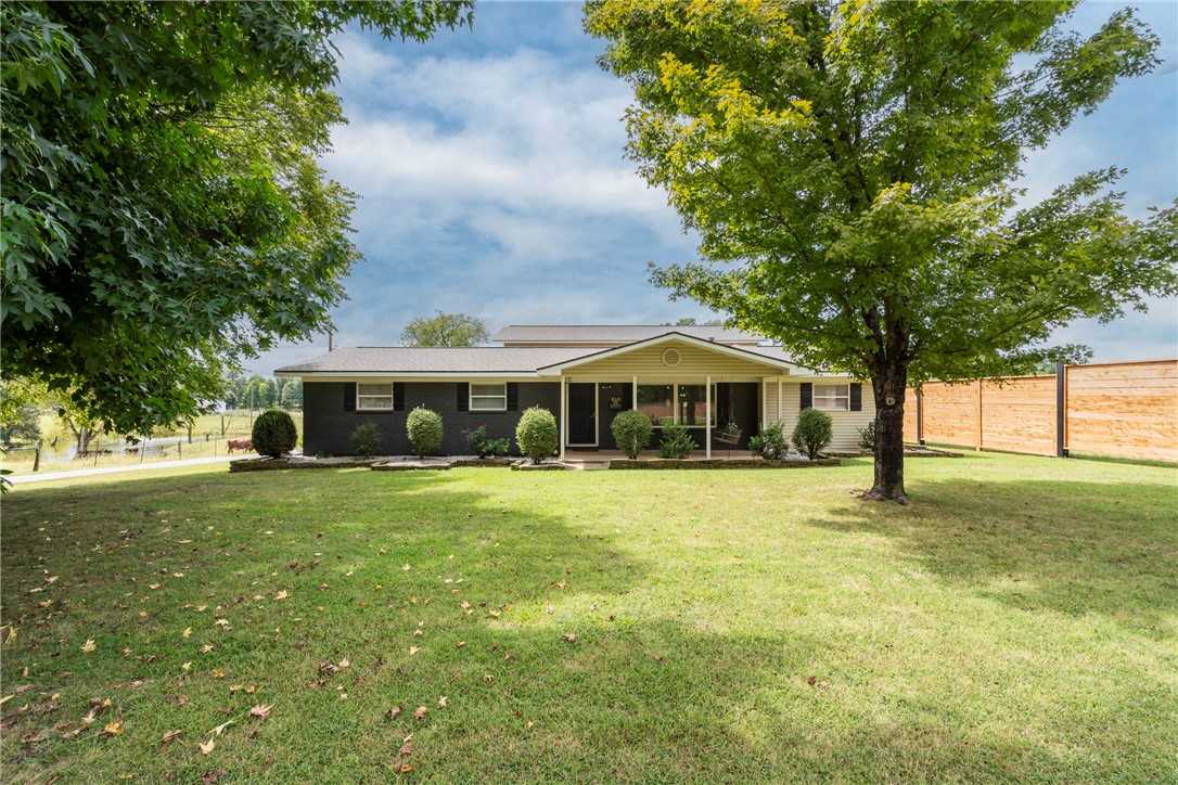 Step onto the inviting front porch and into a spacious living room perfect for gatherings. The backyard features an 18āx36ā saltwater pool, outdoor kitchen, and gazebo, all privately enclosed by a vinyl fence. Inside, the enormous Master Suite offers serene backyard views, a luxurious bath with soaker tub and walk-in shower. Two bedrooms include a built-in library and Murphy Bed for guests. The chefās eat-in kitchen boasts a custom epoxy countertop island, and kids will love the backyard playground. Located just a quarter mile from I-49 for easy access to cycling trails, Bentonville, and Gravette schools, this home offers both convenience and tranquility. With outbuildings and recent updates including a new roof (2019) and pool liner (2022), itās an ideal retreat, short-term rental, or commercial opportunity. Also being offered with 5 acres MLS#1322192
