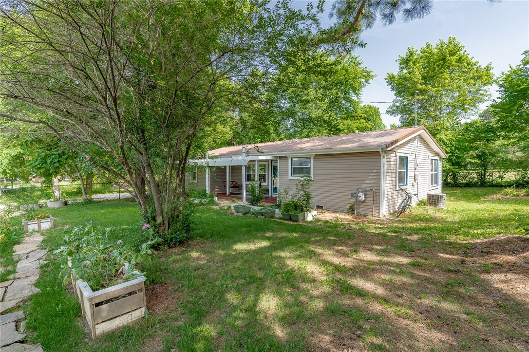 Darling, move in ready, 3/2 home on a big corner lot in South Fayetteville! Close to the U of A, Fayetteville square, and Greenway trail system. Enjoy the mature trees and neighborhood while you hang out on your covered front porch with a swing. The spacious living room welcomes you into the home and has a big picture window. Nice sized kitchen with ample cabinets, upgraded stainless steel appliances, and the fridge conveys. Large laundry room offers additional storage. The split floor plan gives this house a nice, functional flow. The primary bedroom has a fully remodeled bathroom with a tiled walk-in shower. Metal roof and vinyl siding make this home easy to maintain. Cute as can be and in a great location! Come see this excellent home today!
