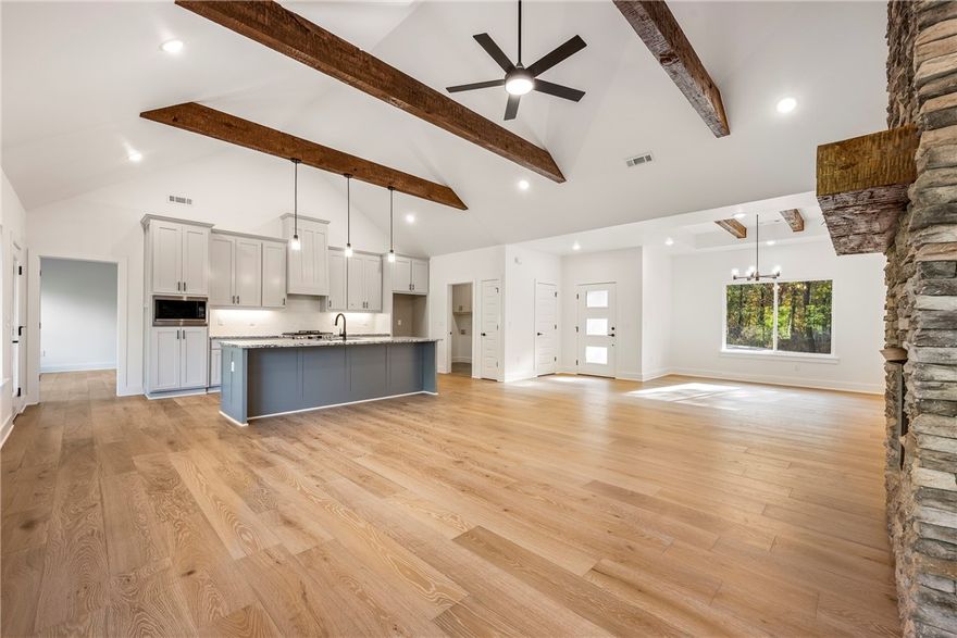 Beautiful new construction by Elite Thomas Homes. 2 bedrooms PLUS an office and media room. The home backs to the Flo Ride bike trail and offers the perfect blend of recreation and convenience—less than a mile from the Lake Ann boat ramp. This thoughtfully designed home features an open-concept living area with vaulted ceilings accented by wood beams. The kitchen and dining spaces provide plenty of room for gathering and entertaining. The laundry room conveniently connects to the primary closet for added functionality. The main level includes two bedrooms plus an office, with wood flooring throughout. The home offers a tiled guest bath and a spacious primary bath with a large tiled shower featuring dual shower heads, a double vanity, and a linen closet. The partial walkout basement includes a media/game room with a wet bar and half bath, with premium carpet on the stairs and lower level. Enjoy outdoor living on two covered decks-one off the kitchen and one from the basement. Perfect for relaxing or entertaining.