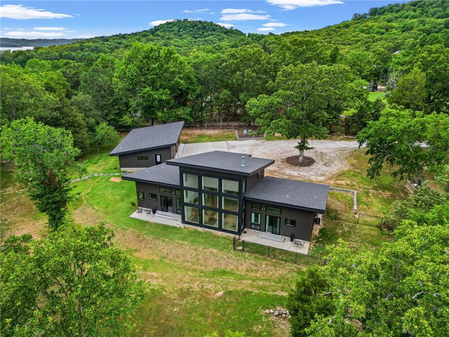 What a find! This Beaver Lake lakefront home has year-round water views, a private boat dock, and over 7 mostly flat acres! Built in 2020, this contemporary home boasts neutral, modern finishes throughout. Large windows invite the outdoors in and create a bright, open, airy atmosphere! Two, main level primary suites flank the centrally located kitchen & great room areas. Another bedroom/office has an oversized closet for extra storage. Upstairs is a full bath and multi-purpose loft that could easily be partitioned off for an additional bedroom suite. The oversized garage has tall ceilings and even a half bath for convenience! There are a variety of outbuildings for storage along with a greenhouse and an enclosed, raised bed area for the gardening enthusiast! The flagstone patio/firepit is a perfect spot to relax and unwind while gazing out over the lake. This rare, flat parcel lends itself to so many uses and provides for a very gentle walk to the single-slip boat dock w/swim deck. Check out the virtual tour video!