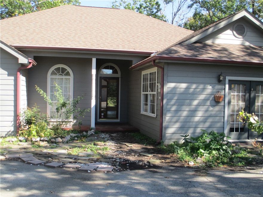 Custom built one owner home awaits your special touch.  Upon entry the spacious open floor plan with 10 foot ceilings  makes up the dining, kitchen & living areas. Natural light streams in from skylights in the kitchen that has a plethora of cabinets including a unique built-in spice closet & extra bar sink. A grand fireplace with gas logs is the focal point in the living area. The primary bedroom & bath includes, dual vanities, separate shower & jetted tub along with two walk-in closets. Additional two bedrooms have built in shelving, walk-in closets, large arched windows & share the hall bath. A huge bonus room which was an artist studio rounds out the single level home.  With a bit of work, this room could be converted back to a garage. Pergolas on either side of the home add additional parking that are easily accessed from the circle drive.  Enjoy the views from the back deck while taking in the sounds of the fountain in the back yard. Priced to sell quickly!