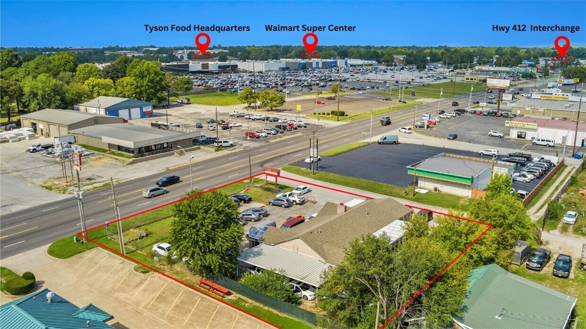 Prime Location on Highway 71! High visibility area across from Tyson offices and walmart, less than a mile from the Highway 412 intersection! Large flat lot with multi car parking, outside storage, and a useful building. Current tenant has an automotive sales business, previous owner had a flea market, the city also approved a mulit unit building opportunity. Buyer to determine if their desired usage is approved. Springdale is home to several large industries accessed by highway 71. Highway 71 is the original gate way to NWA and still sees more than 26000 cars per day in front of this building.
