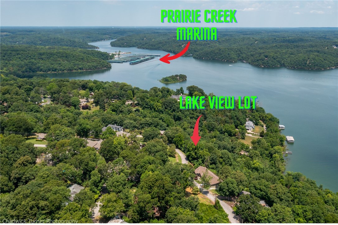 Lot (.81 acre)with STUNNING Beaver Lake Views for sale on a quiet street in Prairie Creek. This beautiful lot is perfect for your custom-built dream home! Located just minutes from Prairie Creek Marina & Downtown Rogers. Lot faces Northeast so enjoy beautiful sunrises year round from the deck of your future dream lake home. All the hard parts are done. 2 lots have been combined,septic plan for 4 bdrm house designed, power pole moved, septic permit for 4 bdrm house,building plans from the architect. Building plans & septic design are available upon request. (Water, gas and electric at street). Seller will include a $25,000.00 builder incentive that can be used towards the construction of the retaining wall, with an acceptable offer.