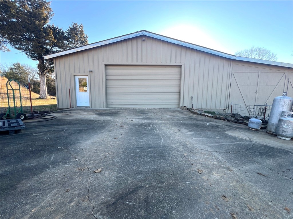 Great Get Away home. Quite peaceful feeling as soon as you leave the highway. Commute to NWA or River Valley. 6 +/- acres. A spring fed Pond. Room to build your dream home. A 4176 sq. ft. Shop with living area inside. Wire Fenced. New septic installed. City Water and O G & E Electric. Shown by appointment only.