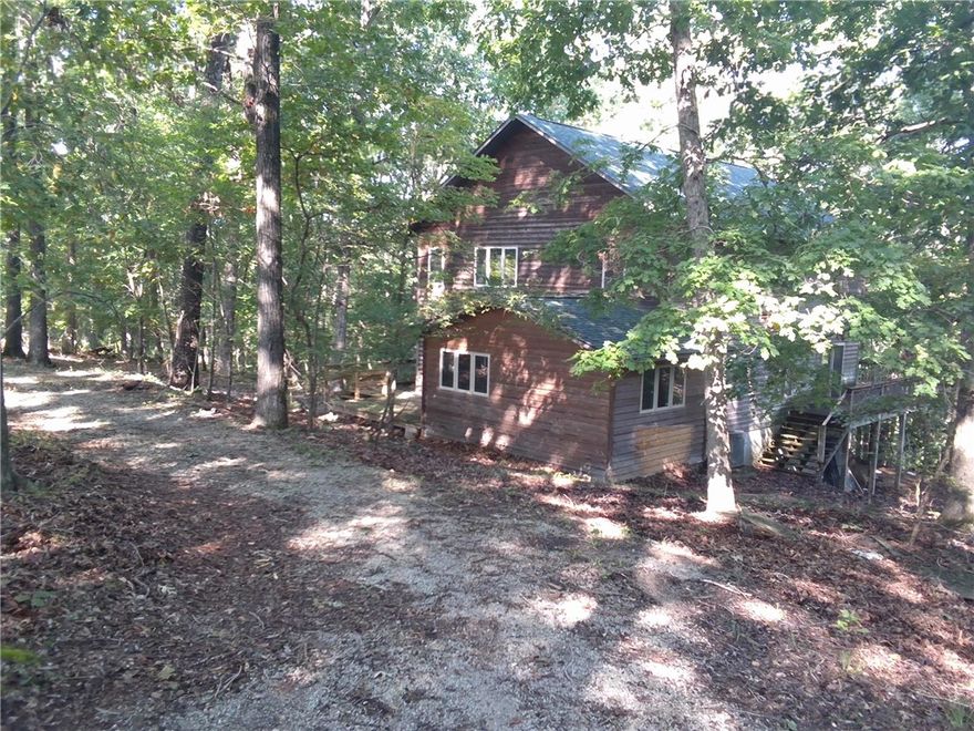 Over 11 wooded acres, this 2-bedroom, 2-bath cabin offers the perfect balance of privacy and rustic charm. Step inside to an inviting open-concept floor plan that fills the home with natural light and warmth. A full unfinished basement provides endless potential for additional living space, storage, or a workshop. Relax and enjoy the peaceful surroundings from the expansive wrap-around deck, ideal for entertaining or simply soaking in the beauty of nature. A convenient circle drive completes this rural retreat, making access easy year-round. Whether you’re seeking a weekend getaway or a full-time residence, this property is a true woodland escape.