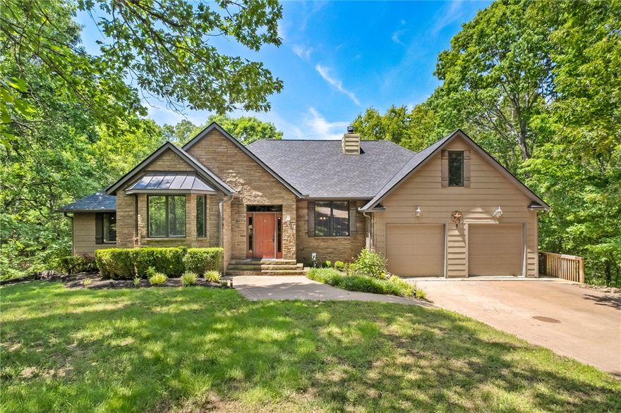Unique opportunity to buy your own Cul-de-sac and a piece of Bella Vista Paradise.  5 Jodrell Lane sits on 6 lots or 2.40 Acres with a 3564sq' home + additional 400sq' Bonus Room over the garage nestled in the trees.  A quality built 4 bdrm, 3.5 bthrm home has poured concrete walls, tankless water heater, low E windows & a sprinkler system for the yard, The living room has vaulted wood beam ceiling, stone woodburning fireplace, built-in shelving and real hardwood floors.  A large eat-in kitchen has Knotty Alder Cabinets, Center Island with Butcher Block Top, Pantry & French doors leading out to a covered upper deck overlooking the trees.  Large primary bedroom features a trey ceiling, newer carpet, walk-in-closet, and ensuite w/  Jacuzzi, Glassed Shower, & double sinks.  Two other bedrooms, full bath, Mud/Laundry Room & 1/2 bath are also on main floor.  The LL walk-out basement has its own full kitchen & bar, 4th bdrm & full bthrm & large family room & stackable Washer/Dryer. LL & side deck. 2.5 garage w/ workshop.