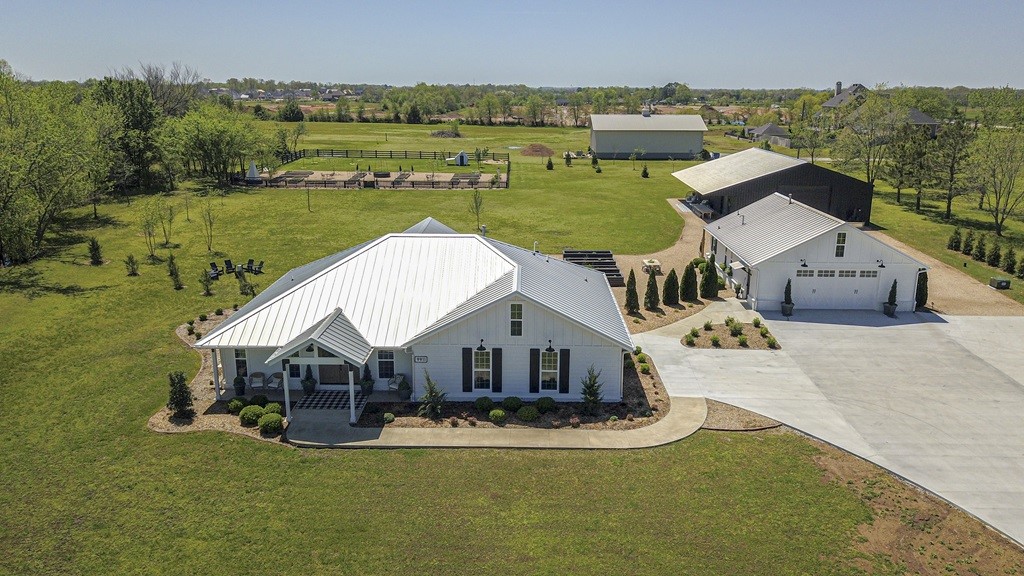 Nestled on +/-2.99 flat acres in heart of Bentonville, this exceptional estate offers the perfect balance of luxury, privacy, and versatility- minutes from Pinnacle Hills, Walmart Home Office, and Downtown Bentonville. Extensively remodeled property just outside city limits with privacy. The meticulously designed primary residence features custom craftsmanship, professional gas range, premium appliances, and seamless indoor-outdoor living. James Hardie siding, designer closets, and extensive built-ins add style and function. A fully equipped guest house provides space for guests, or income-bearing opportunities. Black metal building could serve as an event venue, showroom, or workshop, with a ½ bath and durable metal roof. A 26kW Generac generator & built-in storm shelter offers peace of mind. Professionally landscaped grounds enhance the natural beauty. A rare opportunity for estate-style living with urban convenience in one of Bentonville’s most sought-after locations. 797 SF guest house incld in total heated SF