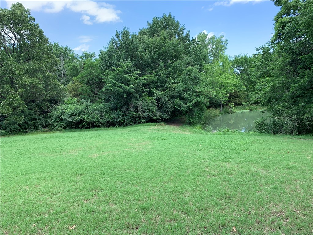 This 3.22 +/- acre parcel, located on the boundary of Fayetteville and Farmington, is ready to be divided into lots or kept as an estate style parcel. The lower sloping topography, studded with beautiful mature hardwoods, is perfect for your walkout basement floorplan and cn be accessed by a private driveway or the ample road frontage. The upper, park-like flat lot overlooks a scenic pond and will have a sweeping view. Only 5 minutes to I49 and 10 minutes to the U of A. With City of Fayetteville Sewer & Black Hills Gas on site & City of Fayetteville Water across the street, all of your utilities are there. In addition, PGTC has just installed their super-sonic speed Zing Internet. Seller had an Engineer perform a water runoff/hydrology study and has a current survey. He has also gained preliminary approval of a proposed 3-lot split from the City of Farmington. Land is zoned for Fayetteville or Farmington Schools. Adjoining 1.54 acres with home, pond and pool listed as MLS#1309552 if additional property is desired.