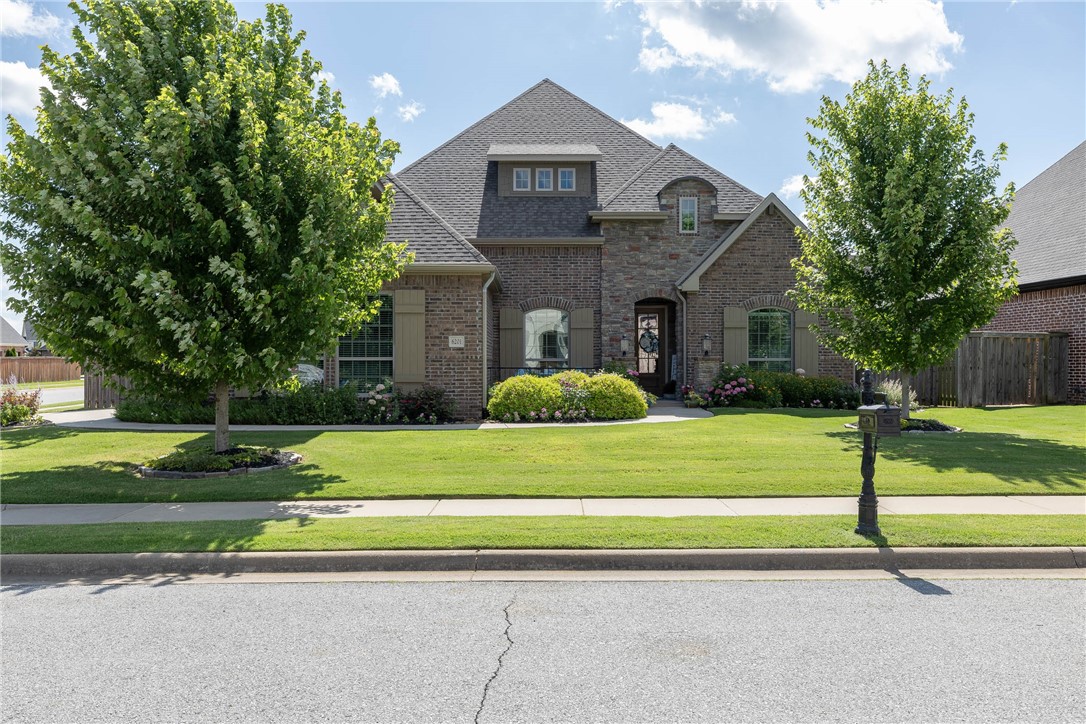 Stunning Corner Lot Home! This showstopper filled with charm; designer touches & incredible flower gardens is everything and more. Ideal layout with 4 bedrooms on the main level & 3.5 baths. Enjoy a light filled open floor plan with double crown molding, gleaming wood flooring, eat in kitchen, spacious formal dining room & your dream kitchen. The chef's kitchen boasts a five-burner gas stove, granite counters, a large island with barstool seating, and a walk-in pantry. Relax in the sunlit primary suite with a luxurious bath & two walk in closets. Thatās not all, the large upstairs bonus room includes a private bath & new mini split. Outside, enjoy a covered patio, extended stone patio, fully landscaped yard with meticulously maintained flower beds. Side-entry three-car garage. Walk to Fairview Elementary & enjoy direct access to the Razorback Greenway