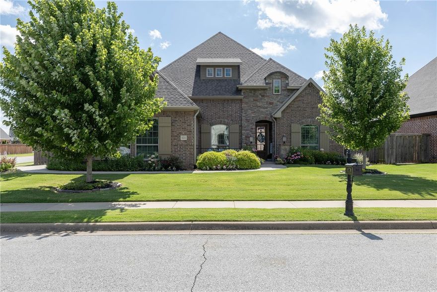 Stunning Corner Lot Home! This showstopper filled with charm; designer touches & incredible flower gardens is everything and more. Ideal layout with 4 bedrooms on the main level & 3.5 baths. Enjoy a light filled open floor plan with double crown molding, gleaming wood flooring, eat in kitchen, spacious formal dining room & your dream kitchen. The chef's kitchen boasts a five-burner gas stove, granite counters, a large island with barstool seating, and a walk-in pantry. Relax in the sunlit primary suite with a luxurious bath & two walk in closets.  That’s not all, the large upstairs bonus room includes a private bath & new mini split. Outside, enjoy a covered patio, extended stone patio, fully landscaped yard with meticulously maintained flower beds. Side-entry three-car garage. Walk to Fairview Elementary & enjoy direct access to the Razorback Greenway