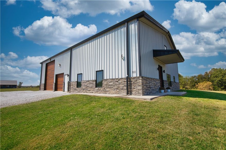 Barndominium situated on 2.5 peaceful acres within the sought-after Bentonville school district in the growing community of Gentry. Offering 1,600 SQ FT of living space, with an open floorplan designed with a modern aesthetic. The kitchen offers sleek granite countertops & seamlessly connects to the living area for ideal entertaining. The primary suite provides dual closets & an oversized tiled walk-in shower. Energy-efficient features include a tankless water heater & 3 mini-split AC units, ensuring year-round comfort & lower utility costs. The shop's bay doors are 9x8 & 14x16 with a space roughly 40x50. The unfinished second floor adds another 1,600 SQ FT, partially installed bathroom & septic lines already in place, ready for you to customize. Check out our photo concepts of the upstairs showing how you can make this space ideal for you. With 10-foot ceilings & the option to create up to 4 bedrooms, this property offers endless possibilities, delivering a blend of upscale living & country charm!