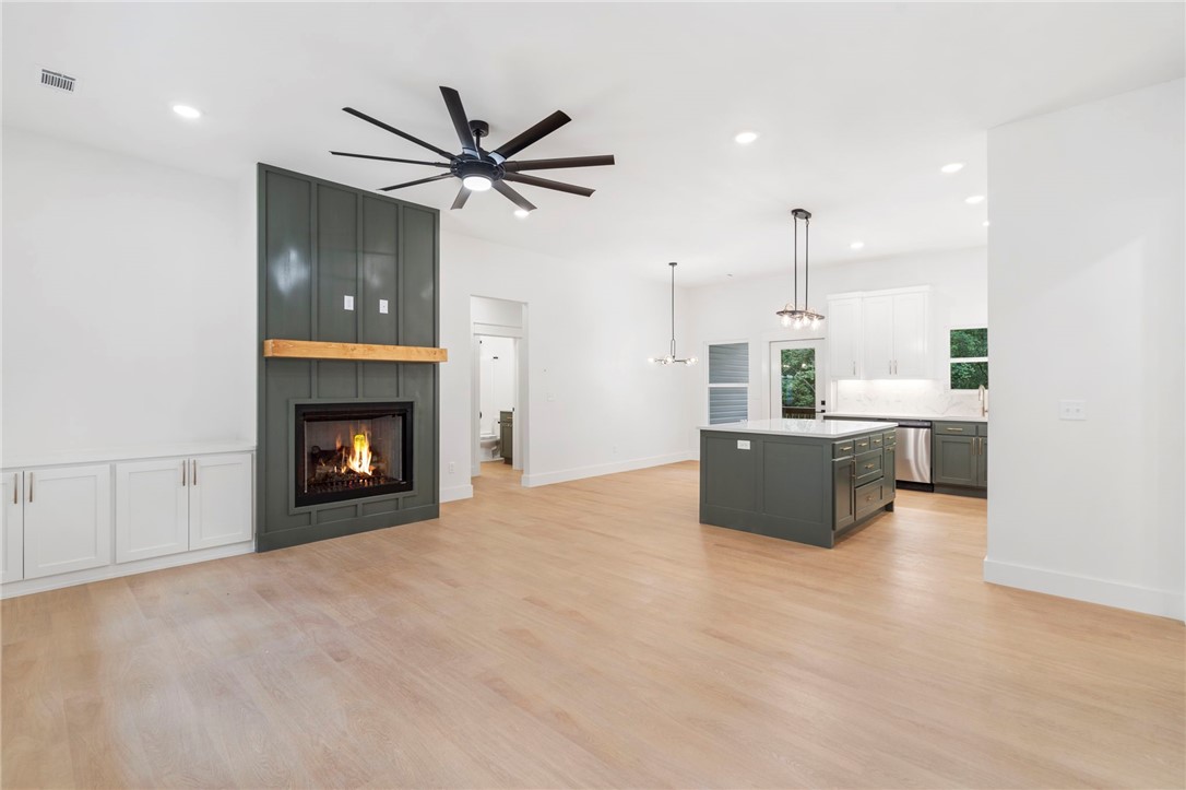 Welcome to this newly built home, showcasing a stunning and functional split floor-plan design that perfectly captures the charm of Bella Vista. A spacious living room is ideal for gatherings featuring a custom fireplace surround and an oversized fan. The kitchen boasts white quartz countertops, custom cabinets, a walk-in pantry, and all appliances installed. The primary suite is a fantastic retreat at the end of the day and is complete with a large closet, full tile in the shower with frameless glass, and a luxurious feel throughout. Enjoy beautiful Bella Vista views in the backyard from the back deck while offering a relatively flat yard. Additional features of the home include LED lighting, champagne accents, and a custom folding table in the utility room. Nestled in close proximity to Branchwood Rec Center and 5 minutes away from Highlands golf course and lake Loch Lomond, discover the ideal blend of a brand new home while living a Bella Vista lifestyle.