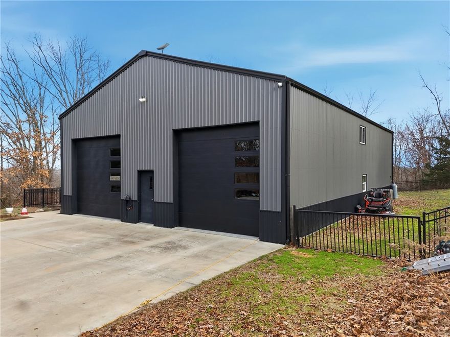 Seller offering $5,000 in buyer concessions! Discover this beautifully crafted home set on over 6 acres just east of Garfield. The kitchen features custom cabinetry, butcher block countertops, & a farmhouse sink. The primary suite is located on main level & offers a private walk-out to the back patio, spacious walk-in closet, & an en-suite bath with double vanities & a large tiled walk-in shower. Upstairs, handcrafted stairs lead to two additional bedrooms, including one oversized room that could serve as a second primary suite. A full bath with a tub/shower combination & classic subway tile completes the upper level. The attached garage/shop provides ample space for two vehicles plus additional storage for equipment or recreational toys. An added bonus is the front 150 feet of the property along Hwy 62, which is zoned commercial, offering potential for business or investment opportunities. Ideally located just 35 minutes from Walmart Home Office, 15 minutes to Beaver Lake access, & 20 minutes to downtown Rogers.