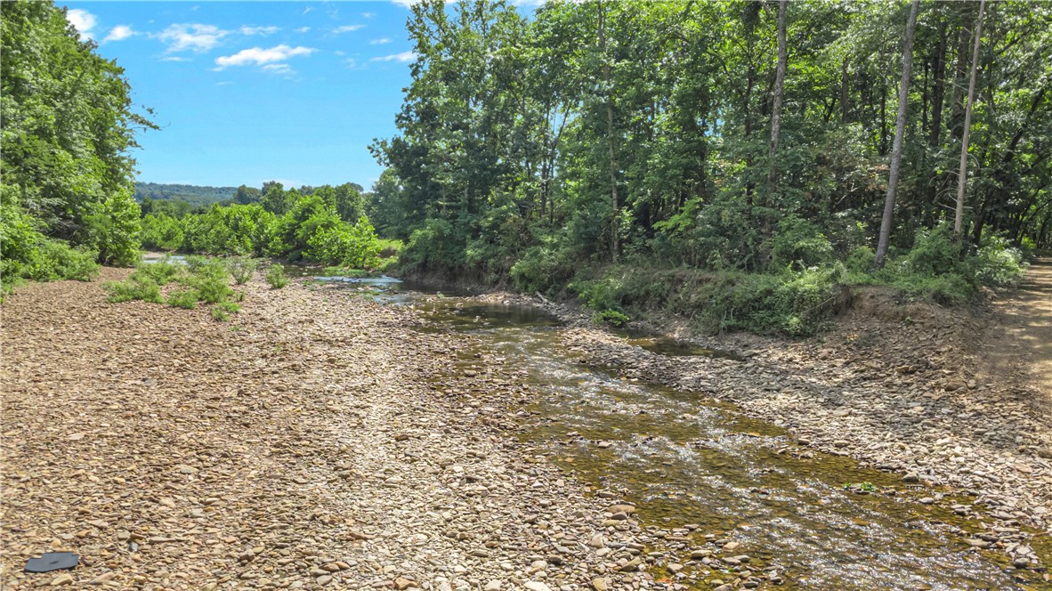 Discover your own Ozark paradise on this rare 55± acre estate with approximately 1,350 feet of pristine War Eagle River frontage, nestled in the heart of the Boston Mountains in Madison County. Surrounded by lush woodlands, this stunning property offers a peaceful retreat with endless recreationāfish or kayak right from your private river access, explore miles of nearby trails, or simply unwind beneath a canopy of hardwoods. The property includes a comfortable home, ideal for country living or weekend getaways, and sits just minutes from natural treasures like Kings River Falls and the iconic Hawksbill Crag. Trailheads and public lands within 10 miles provide exceptional opportunities for hiking, horseback riding, fishing, and hunting. With its perfect blend of seclusion, scenery, and adventure, this estate is a dream for outdoor enthusiasts, nature lovers, and anyone seeking a truly unique rural lifestyle in the scenic heart of Arkansas.