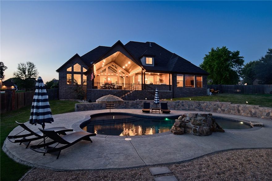 Right inside the private gate of Bentonville's St. Valery Downs is this pristine one owner, custom home on nearly an acre. Smart, functional layout and detailed architectural design. Seamless transitions from living and kitchen into dining and bonus/media room. First floor features an expansive owner’s suite with an elegant spa-like bath and oversized walk-in-closet, 2nd bedroom suite, formal dining or executive study with a neighboring bar. Second floor with three additional bedrooms and bonus room or 6th bedroom. Generous covered patio outdoor living and dining with grill kitchen and a resort style, in-ground saltwater pool, waterfall, tanning deck plus a fire-pit. Just in time for all your Summer hangouts! Featuring the best of functionality; hand-scraped hardwood floors, security system, central vac, storm shelter, oversized pantry and closets, mud room with office space, utility loaded with cabinetry, walk-in attic storage, sprinkler system, sound system and much more! The perfect home to live and entertain.