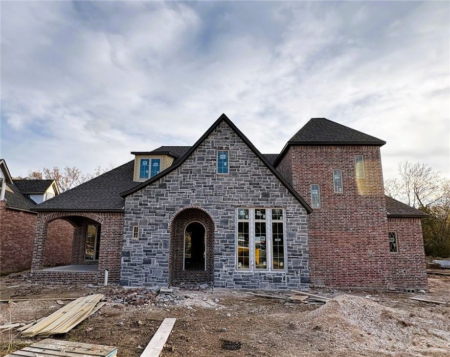 Charming rock and brick cottage-style home offering 3,018 square feet of thoughtfully designed living space. The open-concept main level features refined main living areas and a custom home builder–designed primary suite, creating a private and elevated retreat. Large doors off the living room lead to a spacious patio, perfect for seamless indoor-outdoor living.

Upstairs includes two additional bedrooms and a versatile game room, while a flexible bonus space on the main level can serve as an additional pantry or home office. With 3 bedrooms, 2.5 baths, a 3-car garage, and timeless architectural character throughout, this home blends craftsmanship, comfort, and understated luxury.

This lot requires GSP per City of Fayetteville.