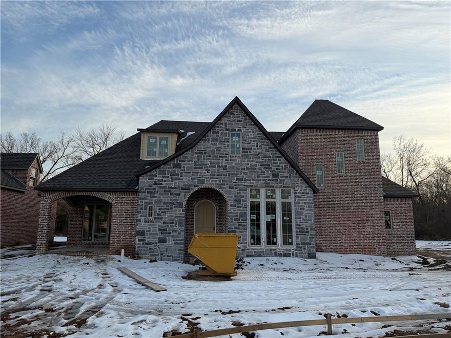 Charming rock and brick cottage-style home offering 3,018 square feet of thoughtfully designed living space. The open-concept main level features refined main living areas and a custom home builder–designed primary suite, creating a private and elevated retreat. Large doors off the living room lead to a spacious patio, perfect for seamless indoor-outdoor living.

Upstairs includes two additional bedrooms and a versatile game room, while a flexible bonus space on the main level can serve as an additional pantry or home office. With 3 bedrooms, 2.5 baths, a 3-car garage, and timeless architectural character throughout, this home blends craftsmanship, comfort, and understated luxury.

This lot requires GSP per City of Fayetteville.