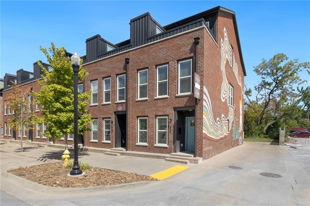 Discover this exceptional corner townhome in the heart of downtown Bentonville, one block from the Skylight Cinema, next to the Hub Bike Lounge. With mixed-use zoning that opens the door to endless possibilities, this property is perfect not only for homeowners but also for investors and entrepreneurs looking to capitalize on a prime location. The downtown trail is right outside your door, offering convenient access for bikers and outdoor enthusiasts. This 3-level townhome features 2 bedrooms and 2 bathrooms, with a main-level bedroom for convenience. The open kitchen and living area on the second floor provide a great space for entertaining, while the third-level primary suite includes an ensuite bathroom and a private patio with neighborhood views. The 1-car garage offers a mini-split system, making it a versatile heated and cooled flex space. Currently used as a real estate office, this property is ready for new ownership as the current owner plans to expand into a larger space.