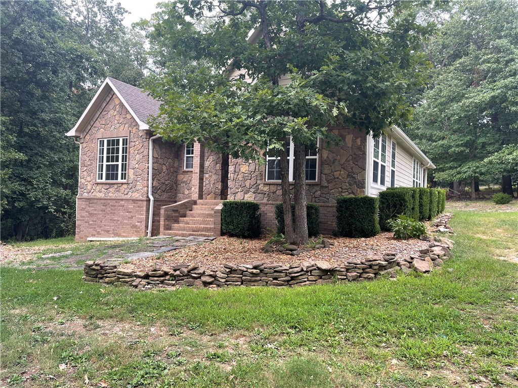 Take a look at this solid built, low maintenance home in a shaded woodsy setting. Attractive brick, stone, and vinyl exterior with covered patio. Split floor plan 3br/2ba with bonus room off of living area. Spacious, well-appointed kitchen with area to gather. Country feel with quick access to hwy 412, schools, shopping, and amenities. Huntsville is a short 10 min drive, Springdale/Fayetteville 25 min away. Nice, comfortable home.