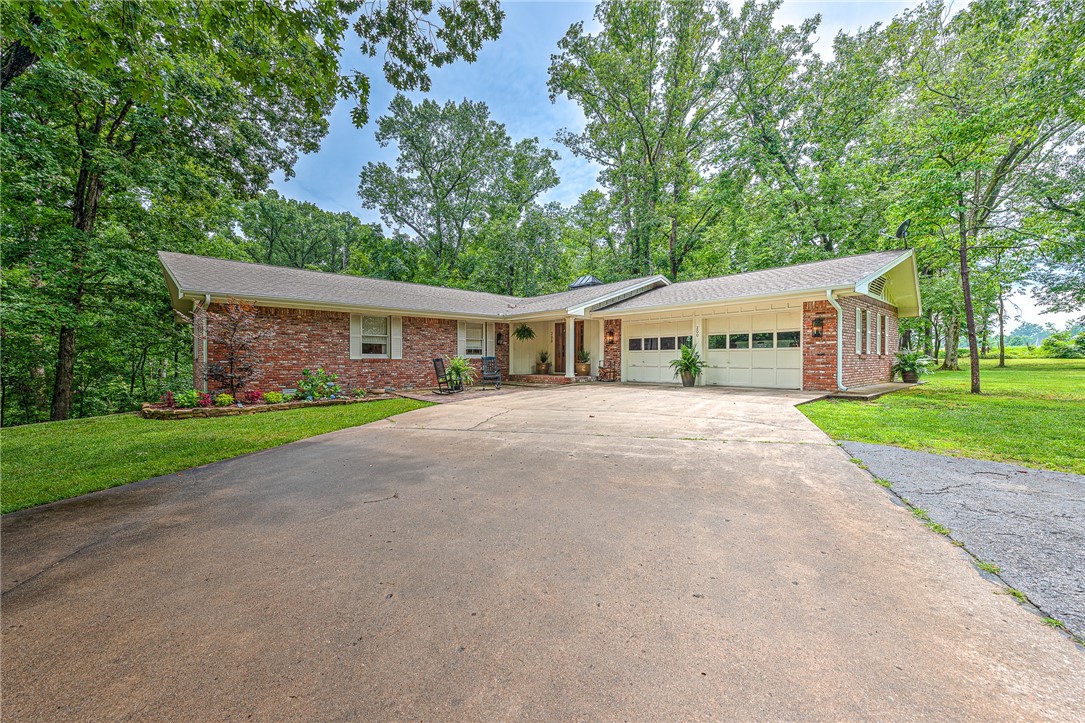 WOW! Your dream property awaits! Nestled on 4 private acres, this hidden gem showcases a fully renovated 3,417 sq ft showstopper, brimming with custom features and gorgeous details! A detached 1,500 sq ft shop offers endless possibilities! The interior offers a clean, sleek, and oh-so-chic farmhouse flair featuring new luxury LVP flooring, designer lighting and custom millwork throughout—including tongue-and-groove ceilings and rustic wood beams. The stunning chef’s kitchen boasts a 12’ island, quartzite countertops, gas cooktop and walk-in pantry. Charming living room w/ cozy wood burning fireplace and a spacious & bright dining space that walks out to the fabulous new cedar deck enjoying private wooded views! Luxurious primary and guest suites on the main level, each with stylish, high-end bathrooms! Full walkout basement w/ bonus/second living, study, bedroom & full bath. Peaceful country living just 15 minutes or less from Beaver Lake/Prairie Creek Marina, the new Walmart campus, I-49, Sam’s Club and more!