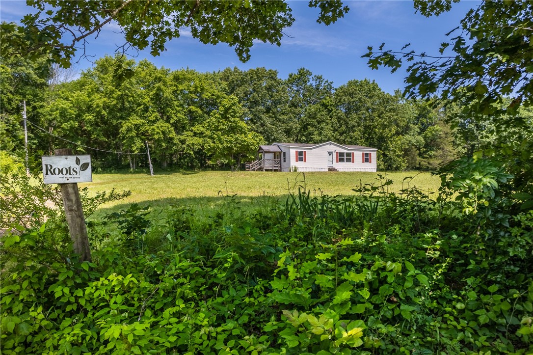 Take a look at this almost 5 gorgeous hillside, mostly cleared acreage with 3/2 mobile home that is ready for a new owner! With a little TLC this home could be ready to live in quickly. Choose to build your dream home, lease, or renovate the house on this chunk of land in the Boston Mountains. Located right off highway 71, it takes about 25 minutes to the U of A, about 15 minutes to i49, near to the famous pig trail, and more! Enjoy the privacy of the country for your own peace of mind, have a few animals, or use this as an escape from town.