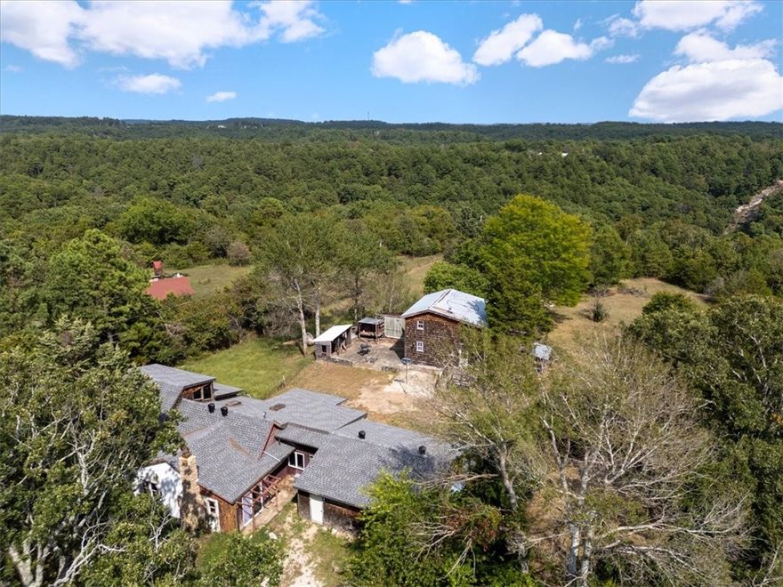Really cool old homestead from 1930 sitting on just over 2 level acres right outside the Eureka Springs city limits. This farmhouse holds such happy memories & has been lovingly updated several times over the decades while this family has owned the property. There is a huge multi story 800+ sq. ft. studio out back that is not included in the square footage that could easily be remodeled into an income producing nightly or long term rental. If you are worried about loosing the studio/workshop to the BnB, fear not, as the conversion of the 650 sq ft garage (not in total sq ft)  into more creative space has cured that dilemma. There is so much square footage that could be utilized in new & exciting ways. The home is certainly livable while under construction and being renovated. The family grew up utilizing a spring for water but that is no longer operational so a water well must be dug or other water source utilized as there is no current water source on location. Potable water can be delivered until the well is dug.