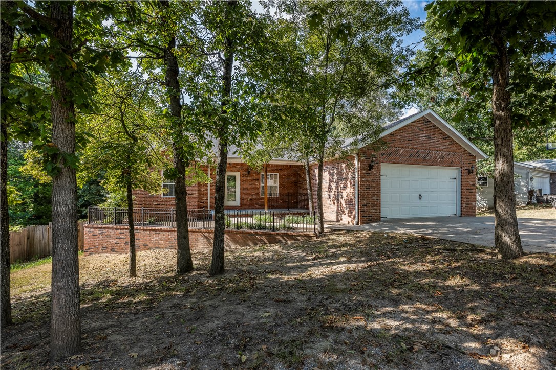Best buy in Bella Vista! Spacious 4 bed, 3 bath, full-brick home in the Bentonville School District, just minutes from trails. This open, split floor plan features hardwood floors, custom tile, granite countertops and crown molding throughout. Enjoy peace of mind with a newer roof and HVAC, new range and microwave. Located on a sewered lot - perfect for creating your dream backyard oasis. Outdoor living includes a porch and deck for relaxing or entertaining. Home needs some TLC but is priced accordingly -- don't miss this opportunity for space, location and value!