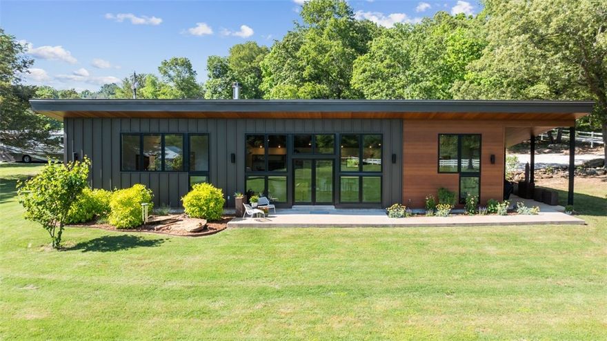 Welcome to your private Ozark Oasis. Situated on just under 4 acres fully fenced  offers ample privacy and serenity. This beautiful modern contemporary home was built in 2020 and is a true masterpiece. The home was designed by local architect Hun-Bae Im who practiced with James Lambeth. The home consists of 2 suites and a large gathering area with soaring ceilings that 
welcomes the outdoor in. The auxiliary building is heated and cooled. You will also find a 50x30 
steel framed barn with endless possibilities. This home is an absolute must see!