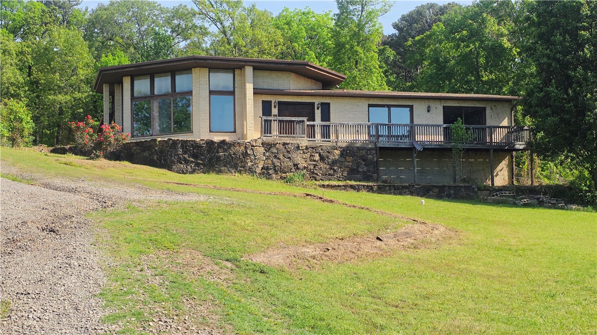 Nestled on a sprawling 2.14-acre lot just outside the vibrant city of Russellville, AR, this 2-bedroom, 2.5-bathroom house offers a unique opportunity for those looking to invest a little effort into a charming property with great potential. The home features a classic design with a combination of brick and wood siding, surrounded by lush greenery and mature trees that create a serene atmosphere. This property has a walk-out basement, offering additional space that can be converted into a den, home office, or recreational area. This versatile space has great potential, but will require some work to realize its full usability and charm. With a bit of effort and imagination, this house can become a delightful retreat on the outskirts of Russellville; offering the tranquility of rural life while still being conveniently close to city amenities.