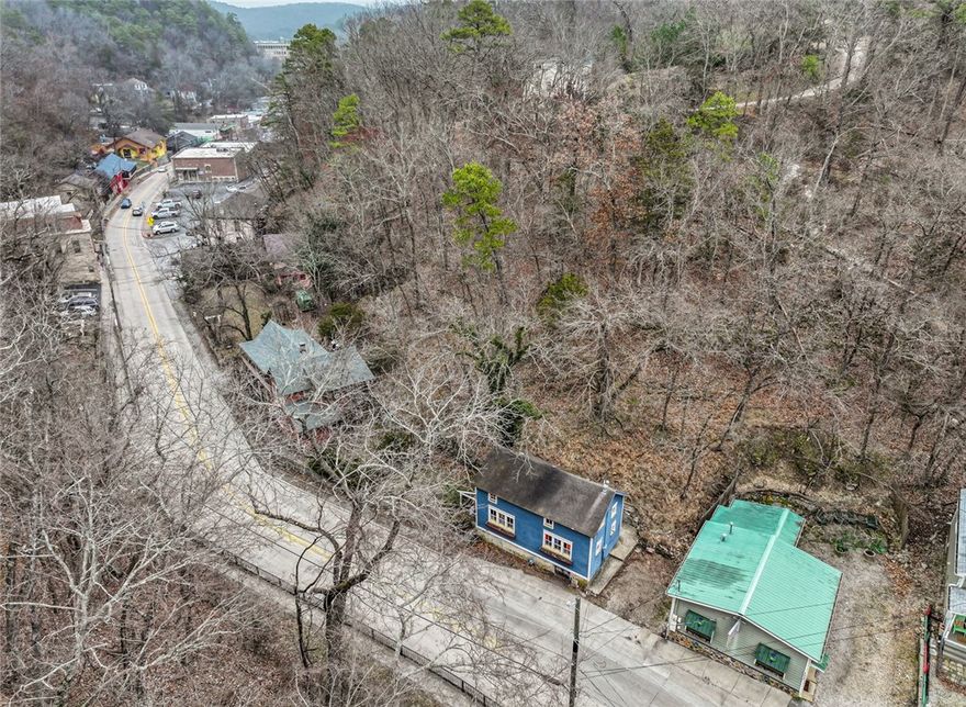 Cobbler's Cottage, nestled in the heart of downtown Eureka Springs, is zoned for commercial use, presenting endless possibilities for business or residential living. Just steps from shopping, charming cafes, and the vibrant energy of town events, this historic 2-bedroom, 2-bath cottage is currently operating as a successful Airbnb, offering both charm & income potential.
Begin your mornings with a cup of coffee on the inviting front porch, overlooking the spacious courtyard, a perfect spot for relaxation. Step inside, & you’ll be transported to a bygone era, where historic character meets modern comfort. The home showcases stunning stained glass windows and timeless architectural details that tell the story of Eureka Springs’ past.
The two well-appointed bedrooms offer cozy retreats, the two full baths ensure comfort & convenience for both residents and guests. The upstairs bedroom, tucked away in a romantic loft with a Jacuzzi tub, adds a unique touch, making it an ideal space for relaxation.  Being sold "AS IS"