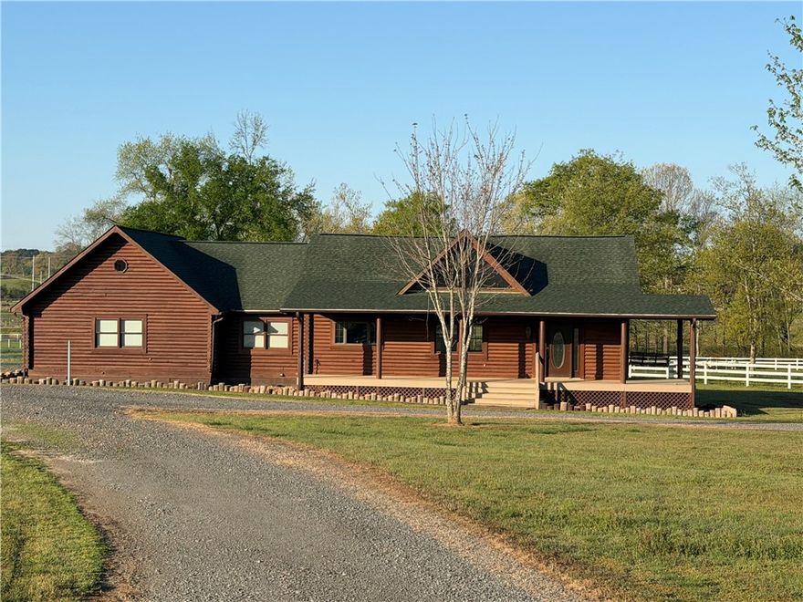 Escape to the peace and privacy of country living with this 5 Bedroom 3 Full Bath full log home with wrap around country style porches located on 3.5 acres.  This one of a kind property combines rustic charm with modern updates, featuring soaring 16 foot cathedral ceilings that create a very open inviting living space perfect for family gatherings or entertaining.  Enjoy peace of mind with HVAC being less than 1 year old and roof replaced 2 years ago. The entire property is fully enclosed with all white vinyl fence, perfect for a couple of horses and adding both curb appeal and functionality.  For those needing workspace the 40x60 work shop with living quarters, 14 foot sidewalls, are ideal with equipment, hobbies or buisness use.    Don't miss your chance to own a unique slice of Arkansas countryside-schedule your showing today!