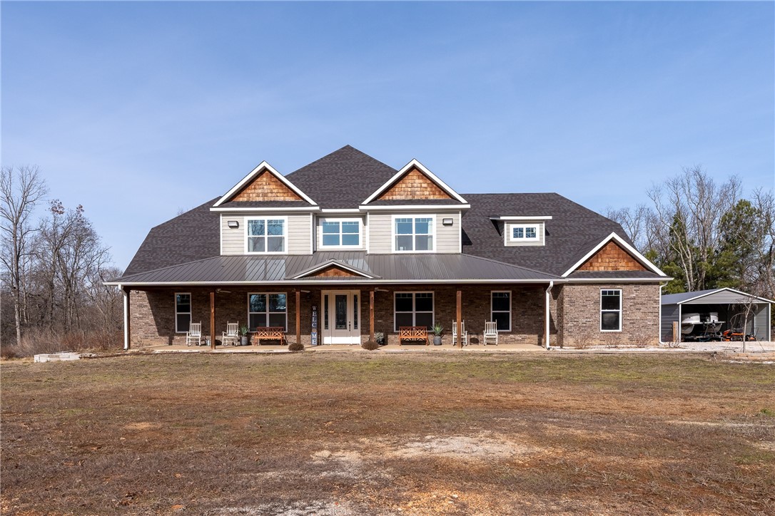 This breathtaking open floor plan home is a must see sitting on nearly 3 acres! From the eye-catching front porch, you enter & are greeted with towering ceilings, & a wealth of natural lighting. There are many custom features, beginning with the beautiful hand scraped hardwoods & custom cabinetry throughout. As you continue through the home, you will find the spacious chefs kitchen with tons of cabinet space, 4 ovens, a gourmet gas range & stunning oversized island. From here you can wander to the back patio, overlooking a newly installed, pool, hot tub, & beautiful nature scenery. The patio is complete with a cozy fireplace & access to the owners retreat where you will find double closets, & a beautiful, walk-in shower. Off the kitchen there is an oversized, dreamy, laundry, room with tons of cabinetry from floor to ceiling, a workstation & a utility sink. Other amenities include an unfinished dog washroom, attic storage, and oversize garage with 8’ x 10’ garage doors, and tankless water heater and a carport.