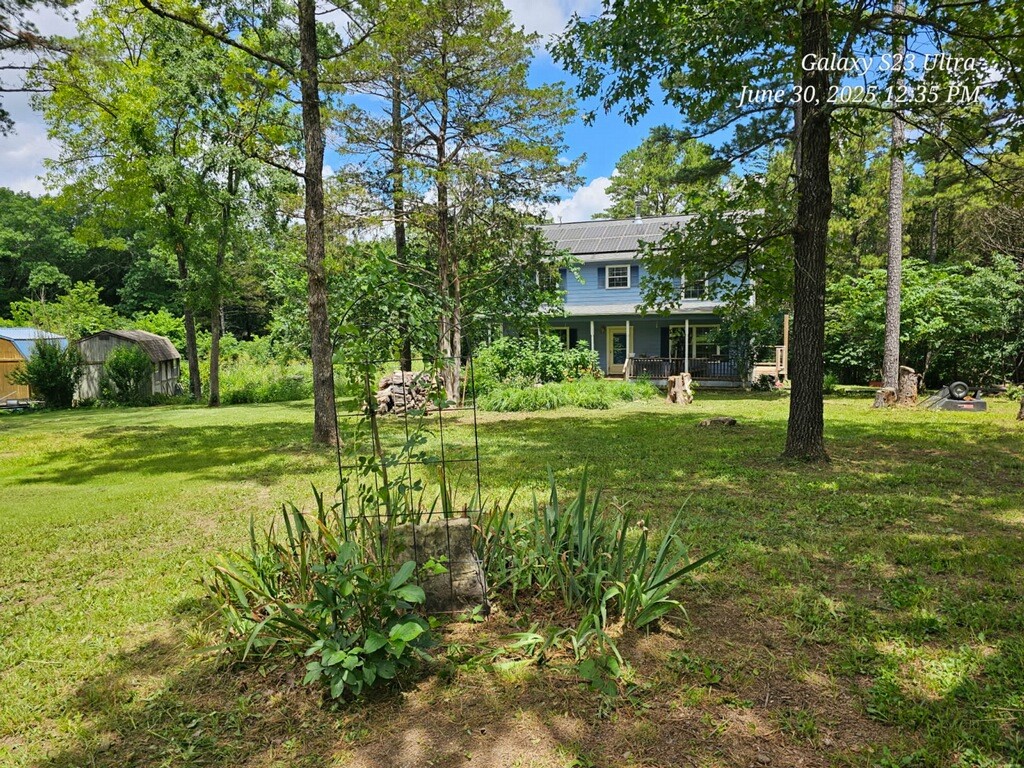 This is NOT in Holiday Island and does not have HOA fees. Mini-Farm on 6.6 acres (Lots 12 & 13). Conveniently located far enough away from the hustle & bustle of Eureka Springs, but close enough for markets, and where entertainment, dining, and outdoor adventure await around every corner. Property includes a garden area, barn with stalls originally used for goats, a chicken yard with hen-house, a couple of smaller Dirksen sheds, and there’s a sunroom at the back of the house for getting plants started early. ..... Solar panels keep the utility bills to minimum, and these will be paid off at closing by seller. Roof under panels replaced <5yrs ago.... Covenants are very light. ... Sellers are both working two jobs (too busy!), so no garden put in this year. ... They're motivated and ready for offers! ... 25' x 30' x 12' steel "Shop in a Box" on-site for purchase separately. Sellers are still moving things out and cleaning up. Some items in barn & raised bed galvanized tub in garden do not convey.