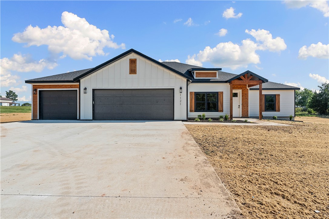 Discover refined modern living with a touch of country serenity in this stunning 1 acre new construction.Featuring 5 spacious bedrooms, 3 stunning bathrooms, and a 3-car garage. Thoughtfully designed with custom cabinetry, detailed trim work, and designer finishes, beautiful natural light, LVP flooring, and a striking feature wall in the living area. The kitchen impresses with quartz countertops, a large island, and a walk-in pantry, while the spa-like primary bathroom offers a freestanding tub, dual vanities, and bold tile accents. Set on a level lot with room to entertain, build a shop, or simply enjoy open space, the property also benefits from a newly paved road and a developing subdivision to the east, enhancing both value and community. Just minutes from downtown Bentonville, this is elevated country living at its best. Lower your interest rate with 7,500 concessions from the seller and up to 5,000 from preferred lender for a total of $12,500.