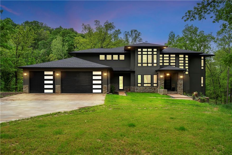 Amazing Location. Ultimate Seclusion meets Luxury! Welcome to your own slice of Bentonville paradise! Stunning 2020 custom-built home sits on 14.62 acres just minutes from downtown and near mountain biking trails. This modern estate offers 5 bedrooms, 5 ensuite baths, flex space, and walk-out basement. Inside, you’ll find 23-ft ceilings, floor-to-ceiling windows with panoramic views, 9-ft doors, and hardwood floors throughout the main living areas. The chef’s kitchen is a showstopper with an 8-burner gas range, farmhouse and vegetable sinks, high-end appliances, and a wine room for entertaining. The primary suite offers a peaceful escape with a private balcony, fireplace, steam shower, and jetted tub. A large mudroom with a built-in dog wash station adds everyday convenience. With 9 flat acres, a year-round creek, and multiple build sites, there’s room for a shop, guest homes, horses, or simply room to roam. Enjoy the perfect blend of luxury, privacy, and nature, right in the heart of NWA. NO Covenants.