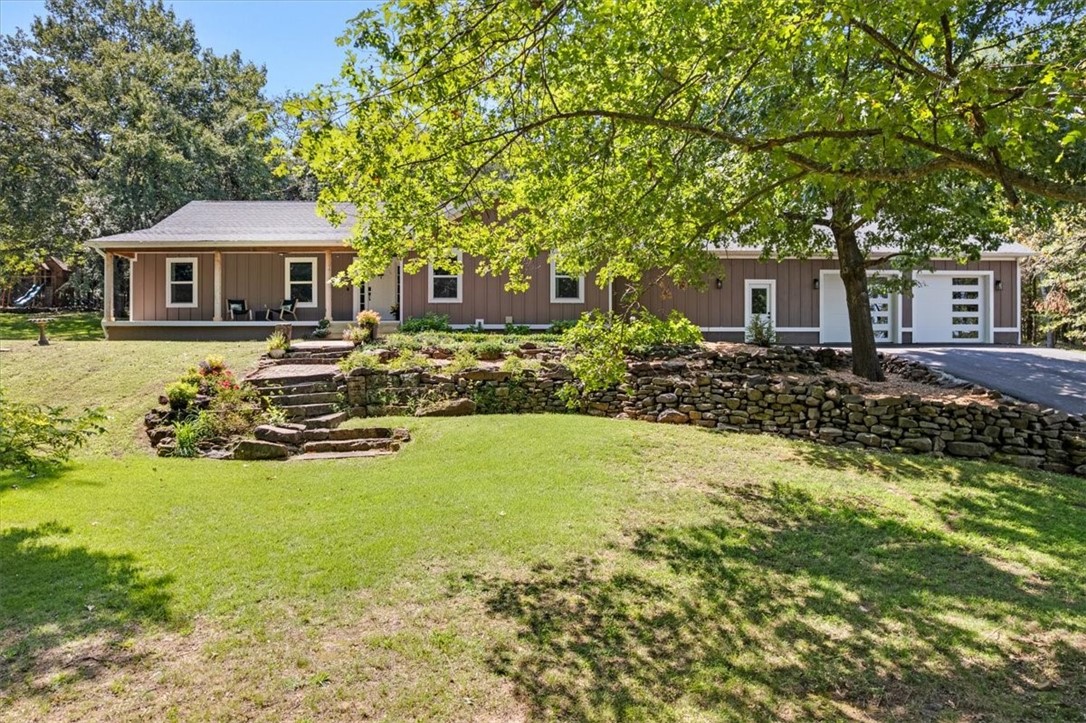 Generational opportunity to own 10.6 acres in the heart of Goshen, AR. This four bed, three bath home was recently updated. Inside you'll find new picture windows capturing the surrounding natural beauty. Enjoy the views from your large kitchen island and stay warm with the handsome wood stove. The covered front porch is perfect for morning coffee. Approx. six of the acres are grassy with shade trees spread throughout. The remaining four acres are timber and home to deer and turkey (rare to find acreage this beautiful so close to town at this price). New roof, floor, & A/C in 2020. Property features a 100 year-old barn with electricity. Three car garage with workbench. Bonus space in garage with climbing wall currently used as an exercise room. Extensive asphalt driveway installed 2022. Invisible fence installed. Walk to the Goshen Community Center to enjoy fresh produce sold at the Goshen Farmers Market. Pancho's restaurant steps away and Orthodox Brewery only 1.5 miles down the road. Fayetteville School District.