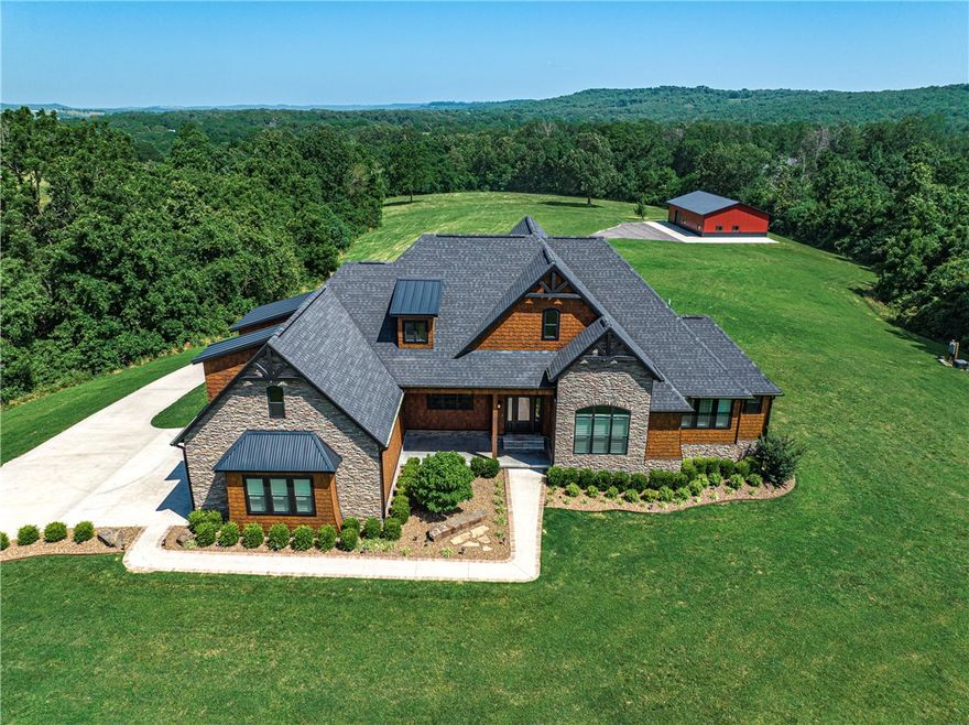 Exquisite estate on 13.44 private acres in Goshen close to Fayetteville.  This 5,144 sq.ft. 5 bed, 4 bath offers superior quality construction to designer finishes.  Enjoy beautiful landscaping with natural AR rocks, see the stars from the hot tub, entertain at the outdoor kitchen or watch a movie in the theater room.  The home includes professional appliances, custom cabinetry, granite countertops and much more.  The 40x60 shop has living quarters and is equipped with 2-50 amp RV hookups.