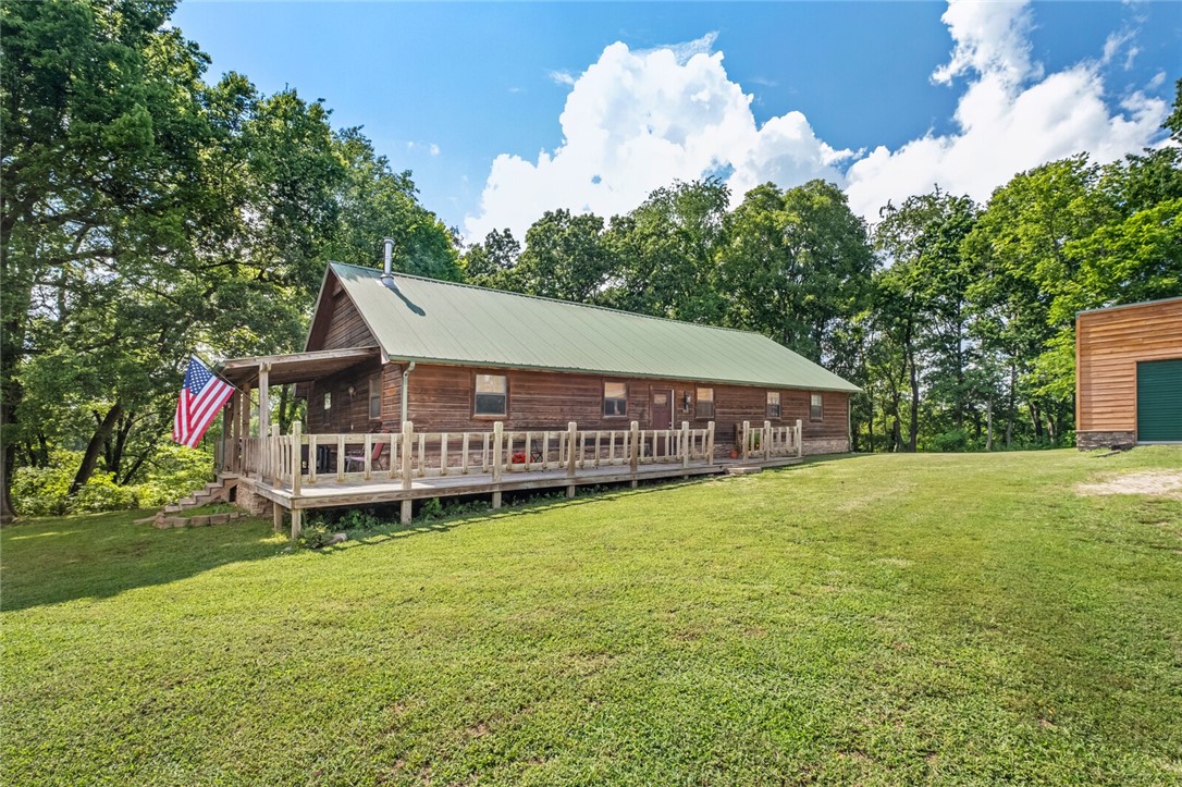 Beautiful cabin living on 5 +/- acres in country setting not far from town! This home features a rustic charm that starts when you walk through the door! Chef's kitchen with dark stained wood cabinets, granite countertops, island with step up bar seating, open concept to the living room that features stone hearth that extends to ceiling behind the freestanding wood stove. Cathedral ceilings in living room that open into the loft area (currently used as home office space) that looks over living & kitchen. Upstairs features BR3 closed off from loft area. Downstairs includes main & 2nd bedrooms along with en-suite main bathroom with custom features of built-in soaking tub, walk-in shower with rock surround, and large walk-in closet. Detached 30x60 shop includes two garage doors, insulated walls w/osb, and plenty of space for projects or storage! New well pump. 6 minute drive to Downtown Pea Ridge.