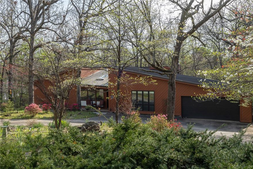 Stunning mid-Fayetteville contemporary home built by David Rose. Located in the secluded Rosewood Addition of Rolling Hills, this 1-level home features 3 full bedroom en suites. The remodeled kitchen has beautiful granite countertops, stainless jenn-aire appliances, craft cabinets and opens to the living room and formal dining room. The grand living room has a sweeping wood ceiling with large skylights, native stone fireplace and opens to a lovely sunroom porch. The primary bedroom boasts a vaulted ceiling, laminate flooring and large walk in closet. A soaker tub centers the primary bathroom with walk-in shower and laundry. One of the suites is set up as a in-law quarter with plumbing setup. The cherry on top is the extraordinary lot studied with trees, landscaping, natural bird habitat. Enjoy soaking in your hot tub on the private deck. There are two flex rooms that could serve as dog rooms, studio space or extra storage. Located near trail access, walkable to grocery store and Butterfield Elementary.Pella windows