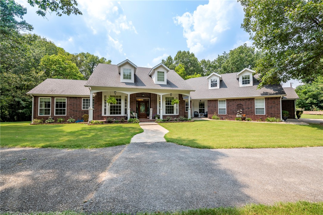 Pretty as a picture, this home radiates warmth & comfort in this exquisite natural setting. This beautiful property offers the main house w/several outdoor living spaces, a rustic cabin guest house & a workshop..all surrounded by woods & trees. Dream kit. w/massive granite top island, SS prof. 5 burner gas range w/dble oven, accented w/a brick archway enhances the richly stained cabinets, soft close drawers, pantry, & brfst area. Crown molding, wood trimmed FP accents the open living area w/a wall of windows & french doors to patio. Mstr. Suite w/sitting area & FP, access to patio, bath w/glass walk-in shower, whirlpool, 2 wics. 2nd Mastr. w/private patio & a safe room. Bonus Room (up), workout room, formal DR, Office/4th bdr., Laundry w/sink & storage. If you're looking for a charming house, well-maintained, w/the quietness of the outdoors tucked away on over 4 wooded acres, yet still close to it all, then this is your dream home! More acreage is available. Contact listing agent.
