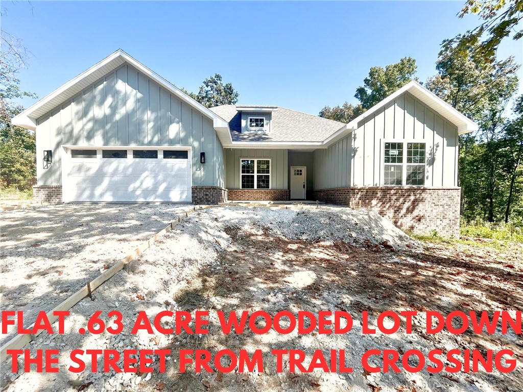 Stunning new construction home on a flat .63 acre wooded lot down the street from the trail crossing! Perfectly situated just minutes from Lake Ann and Metfield Golf Course. Step inside to discover a beautifully designed interior with 3BD's + office, a split floor plan, & high-end modern finishes throughout. Wood floors! The spacious living area showcases a beamed vaulted ceiling, creating an inviting atmosphere. The kitchen features sleek 3 cm quartz countertops, a gas range, custom cabinets, and stylish stainless-steel appliances. Retreat to the luxurious primary bath, which boasts a huge walk-in closet, a large custom walk-in tile shower, and a soaking tub. 2 covered patios. Bentonville schools. As an added bonus, receive $3,500 towards buyer's closing costs when working with the builderās preferred local lender! Approx completion date - 10/15/25