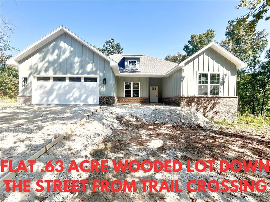 Stunning new construction home on a flat .63 acre wooded lot down the street from the trail crossing! Perfectly situated just minutes from Lake Ann and Metfield Golf Course. Step inside to discover a beautifully designed interior with 3BD's + office, a split floor plan, & high-end modern finishes throughout. Wood floors! The spacious living area showcases a beamed vaulted ceiling, creating an inviting atmosphere. The kitchen features sleek 3 cm quartz countertops, a gas range, custom cabinets, and stylish stainless-steel appliances. Retreat to the luxurious primary bath, which boasts a huge walk-in closet, a large custom walk-in tile shower, and a soaking tub. 2 covered patios. Bentonville schools. As an added bonus, receive $3,500 towards buyer's closing costs when working with the builder’s preferred local lender! Approx completion date - 10/15/25